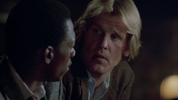 Movie still from “48 Hrs.” (1982), directed by Walter Hill – A man and a black man are talking to each other; Close Up shot, Over the shoulder angle