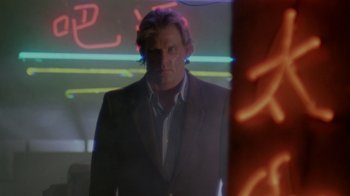 Movie still from “48 Hrs.” (1982), directed by Walter Hill – A man in a suit standing in front of a neon sign; Medium shot, Low angle