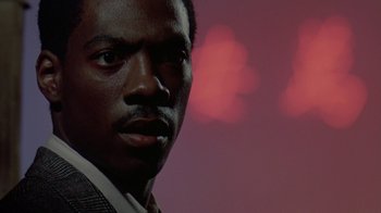 Movie still from “48 Hrs.” (1982), directed by Walter Hill – A person wearing a suit and tie; Close Up shot, Low angle