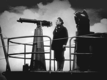 Movie still from “49th Parallel” (1941), directed by Michael Powell – A man standing next to a telescope on top of a boat; Medium shot, Low angle