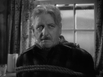Movie still from “49th Parallel” (1941), directed by Michael Powell – An old man tied up with a rope around his neck; Close Up shot, High angle
