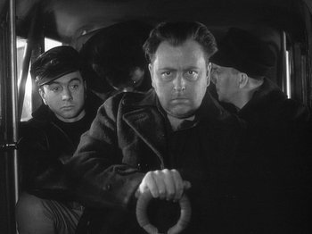 Movie still from “49th Parallel” (1941), directed by Michael Powell – A black and white photo of a man holding a steering wheel; Close Up shot, Low angle