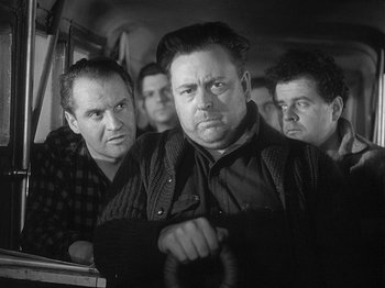 Movie still from “49th Parallel” (1941), directed by Michael Powell – A black and white photo of a group of men on a bus; Medium shot, Low angle