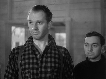 Movie still from “49th Parallel” (1941), directed by Michael Powell – Two men standing next to each other in front of a building; Medium shot, Low angle