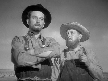 Movie still from “49th Parallel” (1941), directed by Michael Powell – A black and white photo of two men standing next to each other; Medium shot, Low angle
