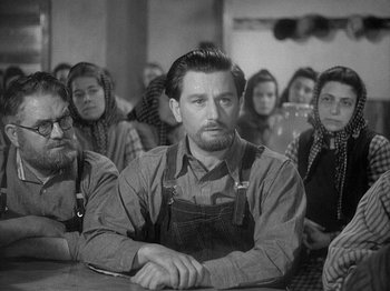 Movie still from “49th Parallel” (1941), directed by Michael Powell – An old photo of a group of people sitting at a table; Medium shot, Low angle