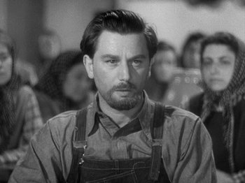 Movie still from “49th Parallel” (1941), directed by Michael Powell – Black and white photograph of a man in overalls; Close Up shot, Over the shoulder angle