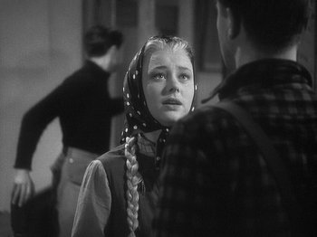 Movie still from “49th Parallel” (1941), directed by Michael Powell – A young woman with a long braid and a polka dot head scarf; Close Up shot, Over the shoulder angle