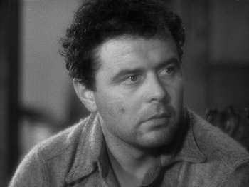 Movie still from “49th Parallel” (1941), directed by Michael Powell – Black and white photograph of a man looking at the camera; Close Up shot, Over the shoulder angle