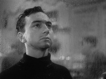 Movie still from “49th Parallel” (1941), directed by Michael Powell – Black and white photograph of a man looking out a window; Close Up shot, Low angle