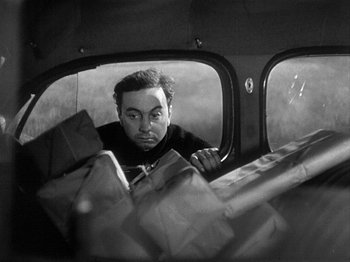 Movie still from “49th Parallel” (1941), directed by Michael Powell – A black and white photo of a man looking out of a window; Close Up shot, High angle
