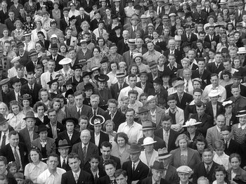 Movie still from “49th Parallel” (1941), directed by Michael Powell – A large group of people wearing hats in a crowd; Wide shot, High angle
