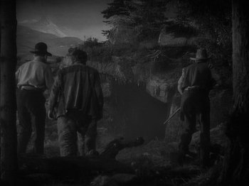 Movie still from “49th Parallel” (1941), directed by Michael Powell – A group of men standing on top of a lush green field; Wide shot, High angle