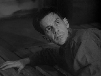 Movie still from “49th Parallel” (1941), directed by Michael Powell – A black - and - white photo of a man lying on the ground; Close Up shot, High angle