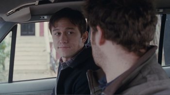 Movie still from “50/50” (2011), directed by Jonathan Levine – A man sitting in the back of a car looking at another man; Close Up shot, Over the shoulder angle