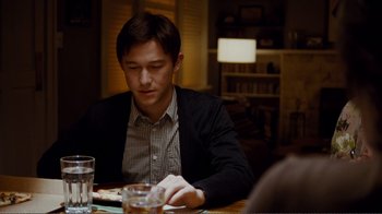Movie still from “50/50” (2011), directed by Jonathan Levine – A man sitting at a table with a glass of water; Medium shot, Over the shoulder angle
