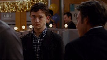 Movie still from “50/50” (2011), directed by Jonathan Levine – A man standing next to another man in front of a crowd; Close Up shot, Over the shoulder angle