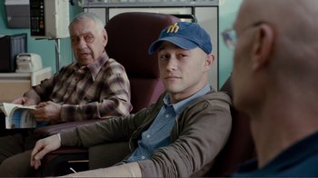 Movie still from “50/50” (2011), directed by Jonathan Levine – A man sitting next to another man on a train; Close Up shot, Over the shoulder angle
