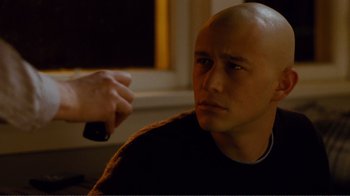 Movie still from “50/50” (2011), directed by Jonathan Levine – A bald man with a shaved head is being shaved by another man; Close Up shot, Over the shoulder angle