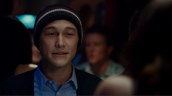 Movie still from “50/50” (2011), directed by Jonathan Levine – A young man wearing a hat is smiling for the camera; Close Up shot, Over the shoulder angle