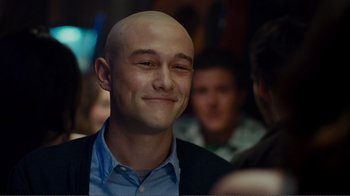Movie still from “50/50” (2011), directed by Jonathan Levine – A man with a bald head smiling for the camera; Close Up shot, Over the shoulder angle