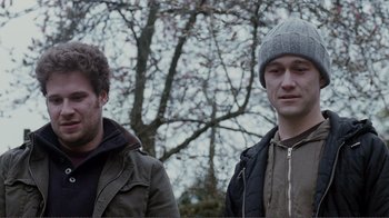 Movie still from “50/50” (2011), directed by Jonathan Levine – Two men standing next to each other in front of a tree; Close Up shot, Over the shoulder angle