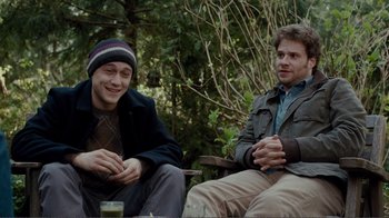 Movie still from “50/50” (2011), directed by Jonathan Levine – Two young men sitting on a bench in the woods; Medium shot, Over the shoulder angle