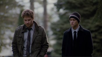 Movie still from “50/50” (2011), directed by Jonathan Levine – Two men standing next to each other in a forest; Medium shot, Over the shoulder angle