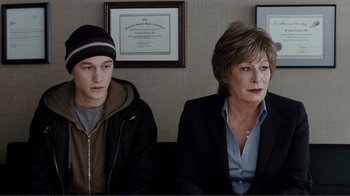 Movie still from “50/50” (2011), directed by Jonathan Levine – A man and a woman sitting next to each other in a room; Medium shot, Over the shoulder angle
