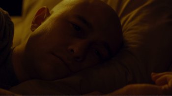 Movie still from “50/50” (2011), directed by Jonathan Levine – A man with bald head laying in a bed; Close Up shot, Overhead angle