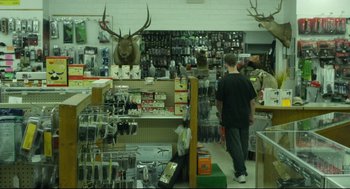 Movie still from “600 Miles” (2015), directed by Gabriel Ripstein – A man walking through a store filled with lots of items; Wide shot, High angle