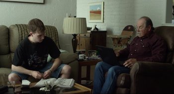 Movie still from “600 Miles” (2015), directed by Gabriel Ripstein – Two men sitting in a living room with a laptop; Medium shot, Over the shoulder angle