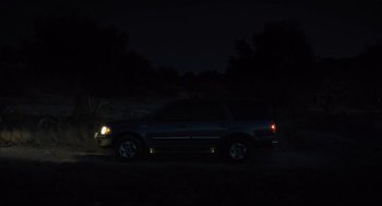 Movie still from “600 Miles” (2015), directed by Gabriel Ripstein – A car parked in the dark at night with headlights on; Extreme Wide shot, High angle