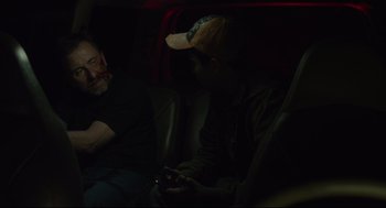 Movie still from “600 Miles” (2015), directed by Gabriel Ripstein – Two men sitting in the back seat of a car at night; Medium shot, Over the shoulder angle