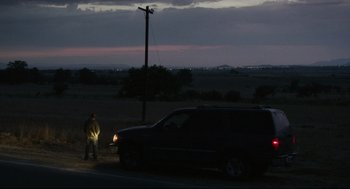 Movie still from “600 Miles” (2015), directed by Gabriel Ripstein – A man standing on the side of a road next to a car; Extreme Wide shot, Over the shoulder angle
