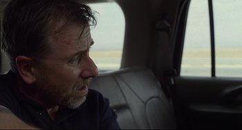 Movie still from “600 Miles” (2015), directed by Gabriel Ripstein – A man sitting in the back seat of a car looking out the window; Close Up shot, Over the shoulder angle