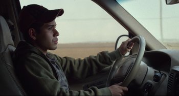 Movie still from “600 Miles” (2015), directed by Gabriel Ripstein – A man driving a car in the middle of the day; Close Up shot, Over the shoulder angle