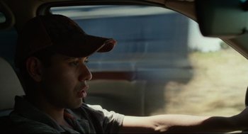 Movie still from “600 Miles” (2015), directed by Gabriel Ripstein – A man wearing a baseball cap sitting in the driver's seat of a car; Close Up shot, Low angle