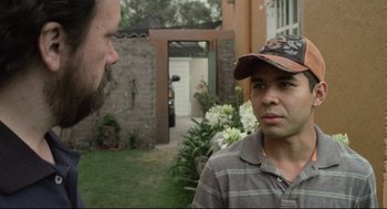 Movie still from “600 Miles” (2015), directed by Gabriel Ripstein – A man and a man with a hat talking in a yard; Close Up shot, Over the shoulder angle
