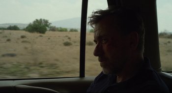 Movie still from “600 Miles” (2015), directed by Gabriel Ripstein – A man sitting in a car looking out the window; Close Up shot, Over the shoulder angle