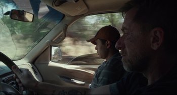 Movie still from “600 Miles” (2015), directed by Gabriel Ripstein – A man and a man in a car driving down a road; Medium shot, Over the shoulder angle