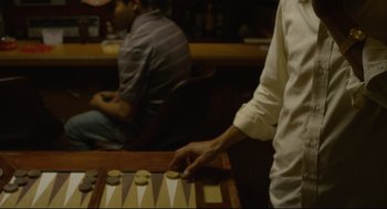 Movie still from “600 Miles” (2015), directed by Gabriel Ripstein – Two men are playing backgammon in a bar; Extreme Close Up shot, High angle