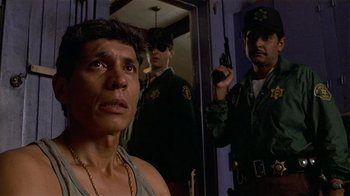 Movie still from “8 Million Ways to Die” (1986), directed by Hal Ashby – A group of men standing next to each other in front of a mirror; Close Up shot, Low angle