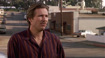 Movie still from “8 Million Ways to Die” (1986), directed by Hal Ashby – A person standing on a street; Close Up shot, Low angle