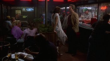 Movie still from “8 Million Ways to Die” (1986), directed by Hal Ashby – A man and a woman are standing in front of a bar; Wide shot, Over the shoulder angle