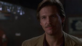 Movie still from “8 Million Ways to Die” (1986), directed by Hal Ashby – A person wearing a suit and a mustache; Close Up shot, Low angle