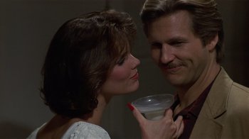 Movie still from “8 Million Ways to Die” (1986), directed by Hal Ashby – A man and a woman are holding a glass of milk; Close Up shot, Over the shoulder angle
