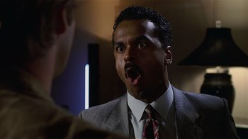 Movie still from “8 Million Ways to Die” (1986), directed by Hal Ashby – A person wearing a suit and tie; Close Up shot, Low angle