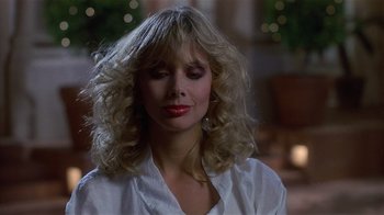 Movie still from “8 Million Ways to Die” (1986), directed by Hal Ashby – A woman in a white shirt is looking down; Close Up shot, Low angle