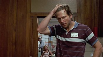 Movie still from “8 Million Ways to Die” (1986), directed by Hal Ashby – A man in a striped shirt is holding his head; Close Up shot, Low angle